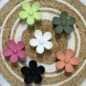 Pastel blossom hair claw clips in assorted pastel colours arranged on a woven mat.